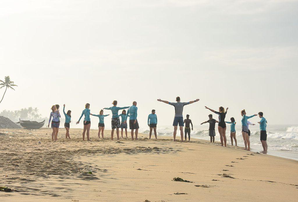 Soul & Surf ISA-certified coach explaining surf techniques on the beach
